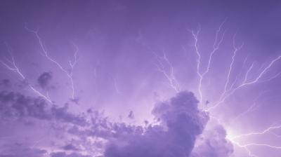 lightning over a purple sky with clouds.